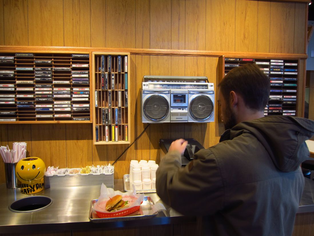 Wall mounted cassette racks above the ketchup dispensers at Genuine Roadside